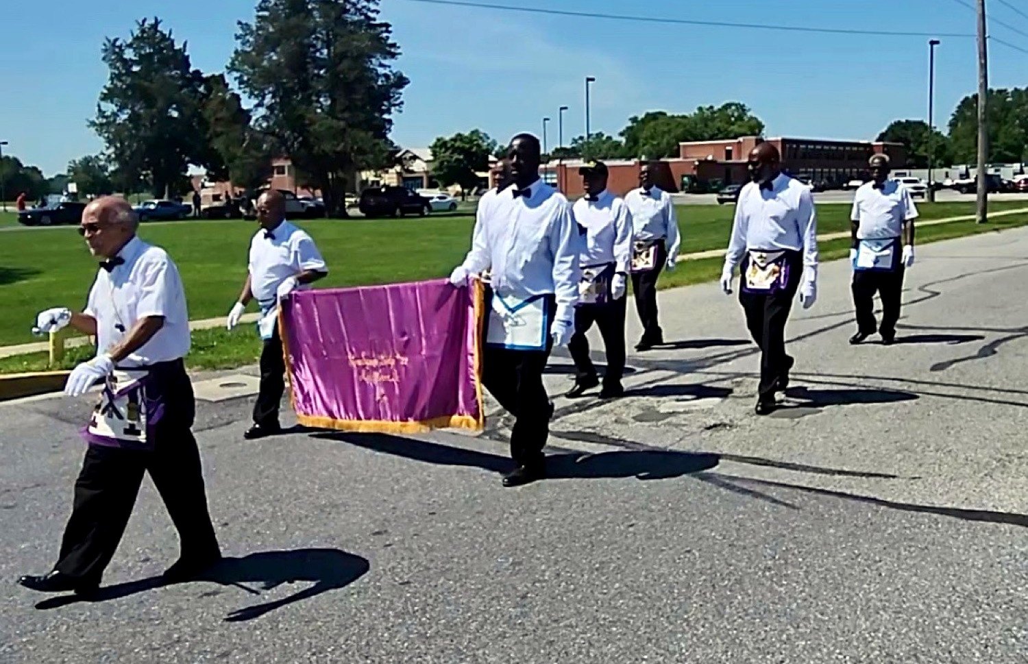 Brothers of Stone Square Lodge No. 22 in aprons and white gloves, carrying the Lodge banner in procession